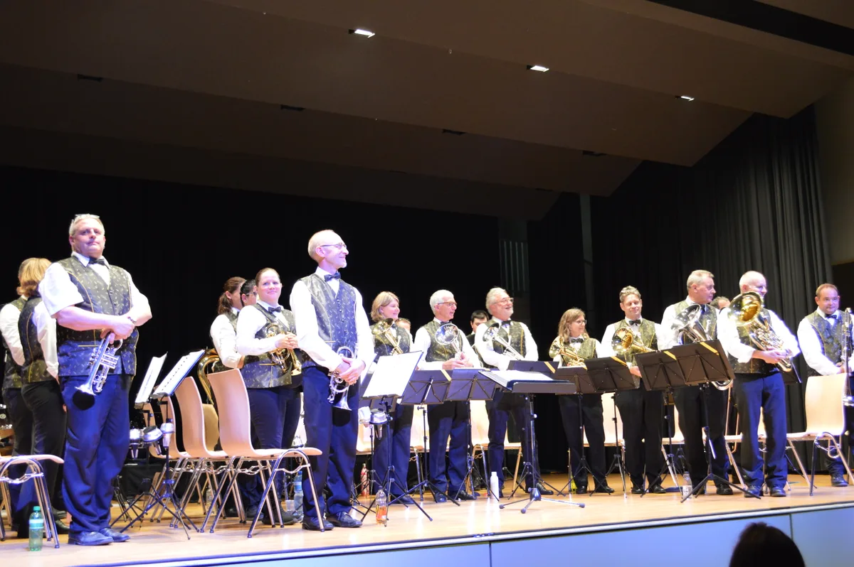 Eine Brass Band auf der Bühne in einheitlicher Kleidung.